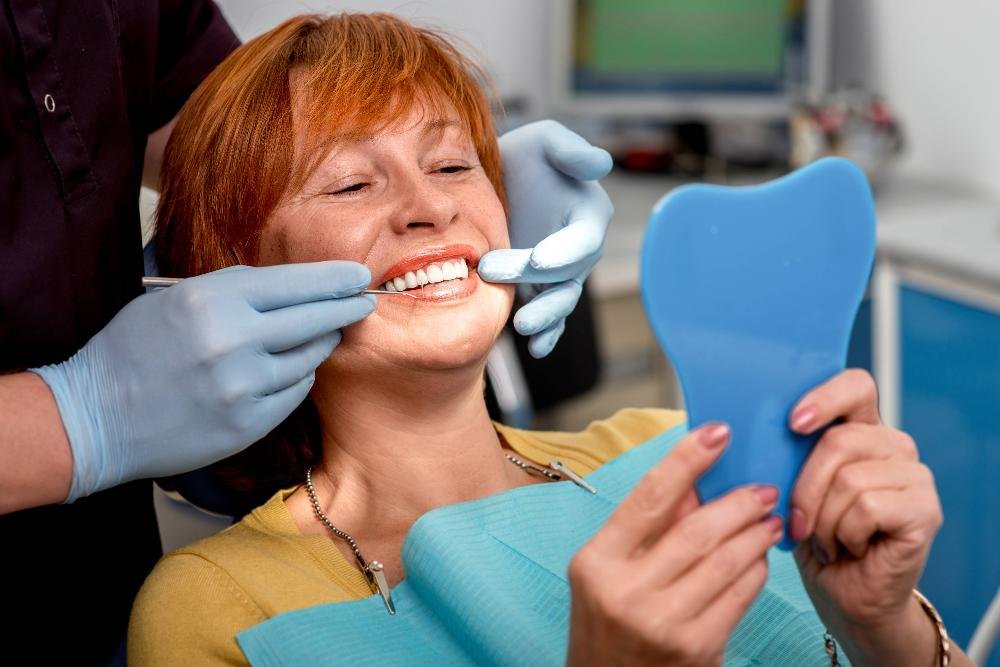 woman smiling with mirror in chair | dentist los gatos ca