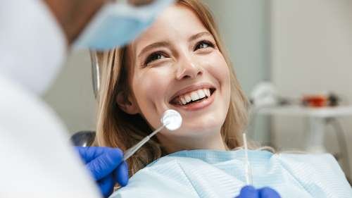 woman sitting in dentist exam chair | dental cleanings in los gatos