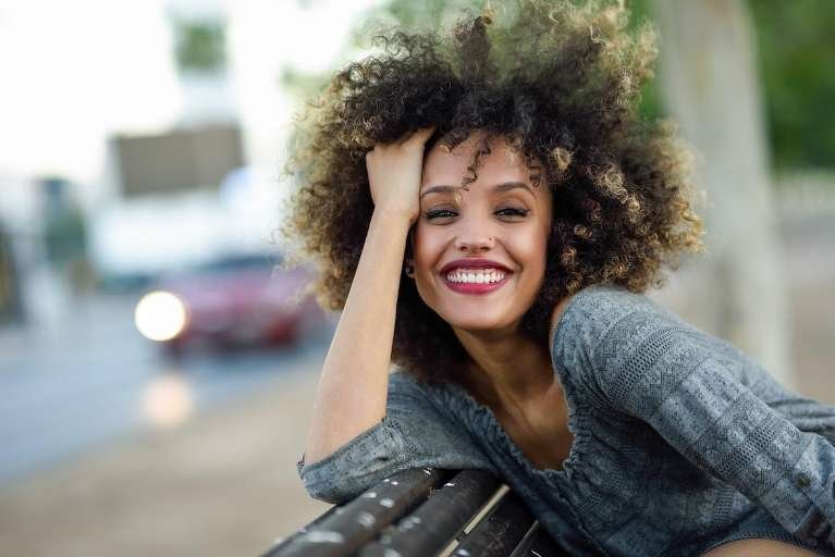 woman with curly hair smiling | resin infiltration near me